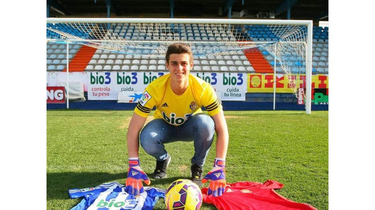 Kepa Arrizabalaga posa en el césped de El Toralín con las camisetas de la Deportiva y España.