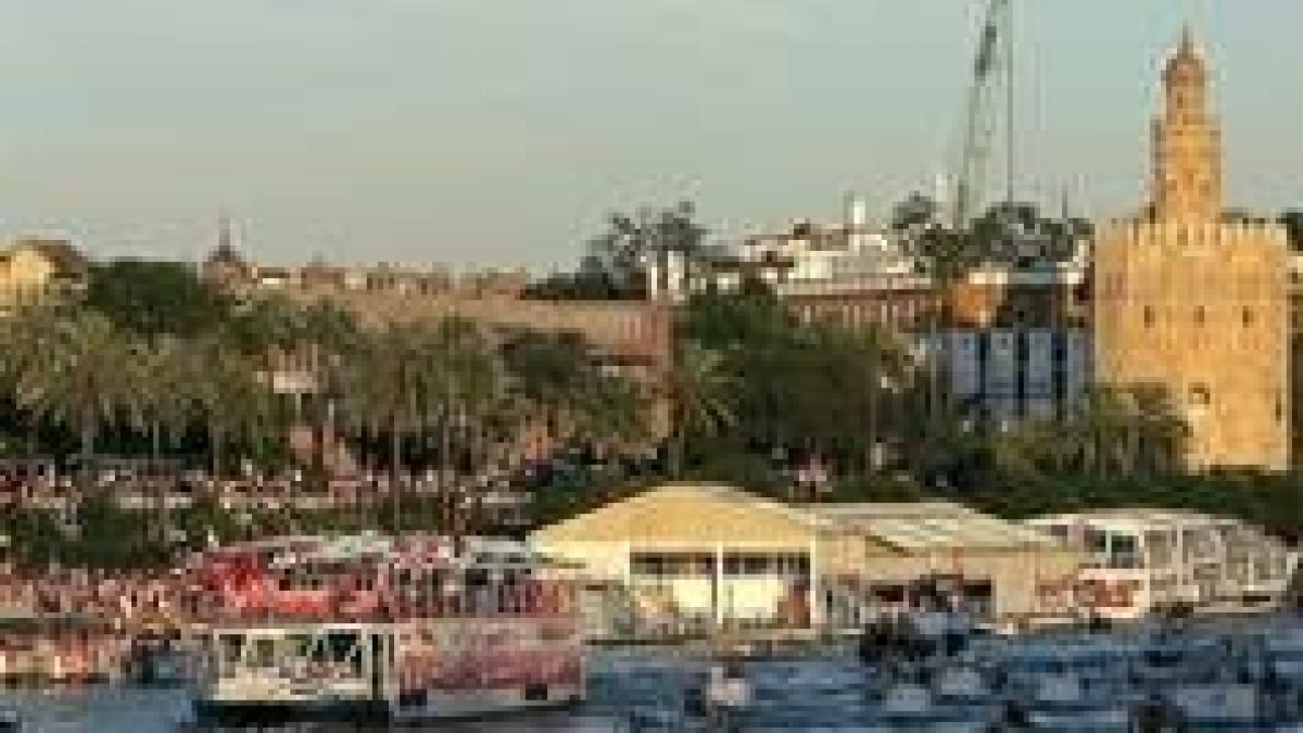 Los seguidores vitorean al Sevilla a la orilla del Guadalquivir y en barcos