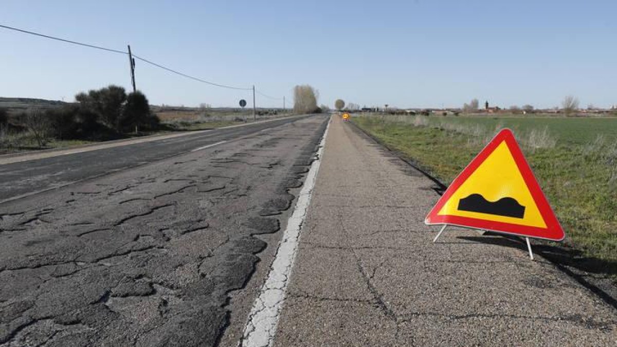 Una señal alerta del mal estado del firme en la carretera que une León con Benavente.