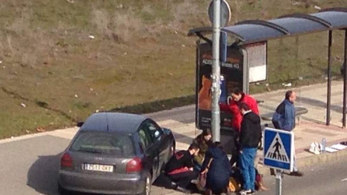 Los transeúntes atienden a la mujer en la acera hasta la llegada de la ambulancia