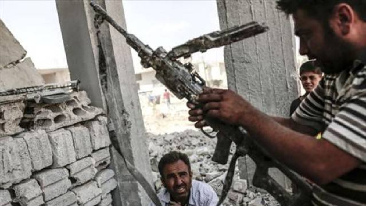 Un hombre con un arma incautada el Estado Islámico en Kobane.
