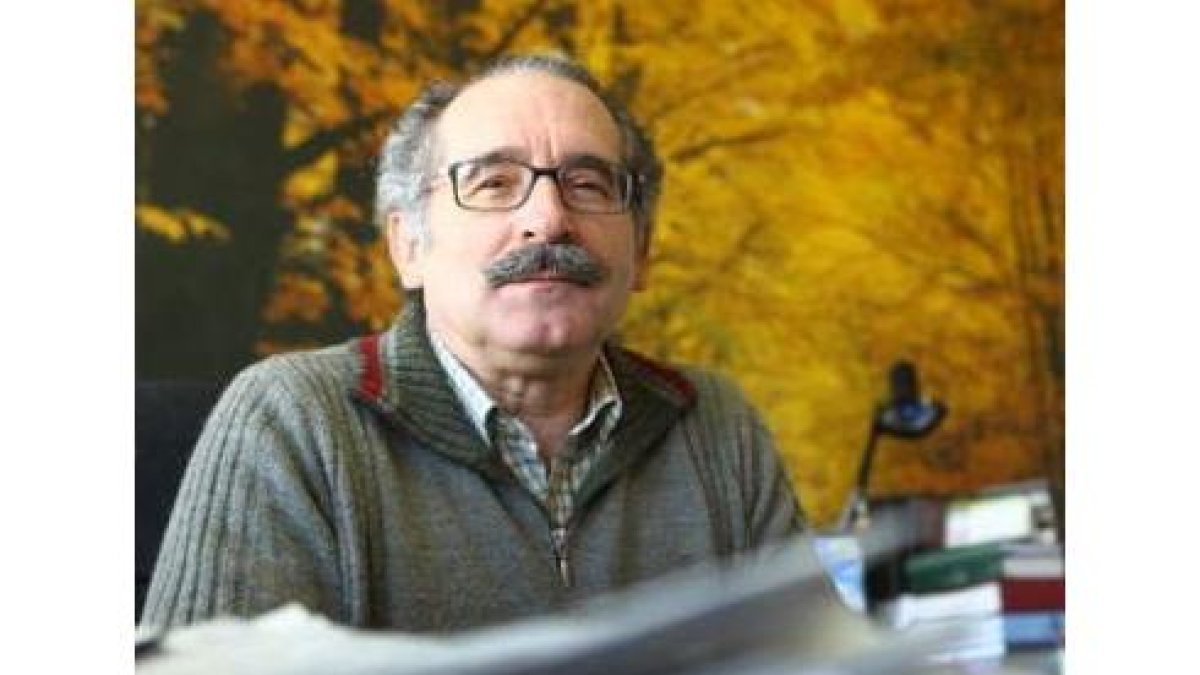 Estanislao de Luis Calabuig en su despacho del campus, donde tiene una gran fotografía de un hayedo.
