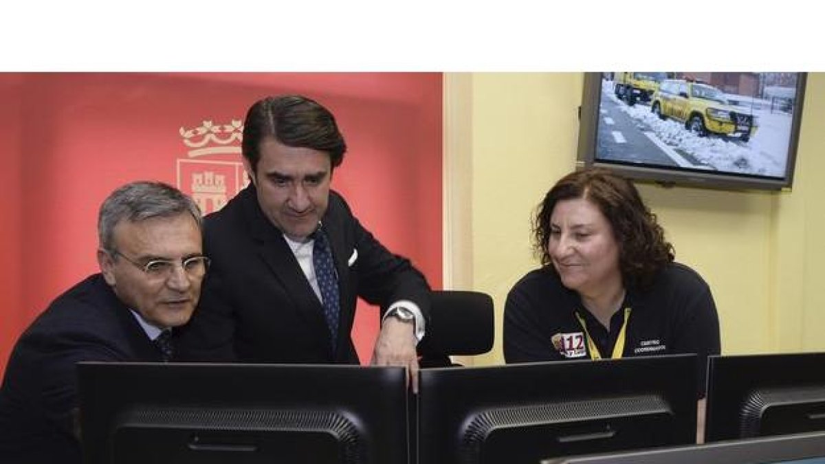 El consejero de Fomento y Medio Ambiente, Juan Carlos Suárez-Quiñones (c), junto al director de la Agencia de Protección Civil, José Luis Ventosa (i), y una técnico del 112, observan unas pantallas tras la presentación del balance de 2016.