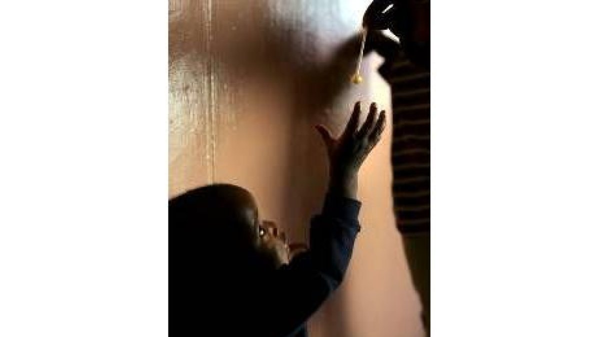 Un niño enfermo de sida alza los brazos para coger un chupa chups
