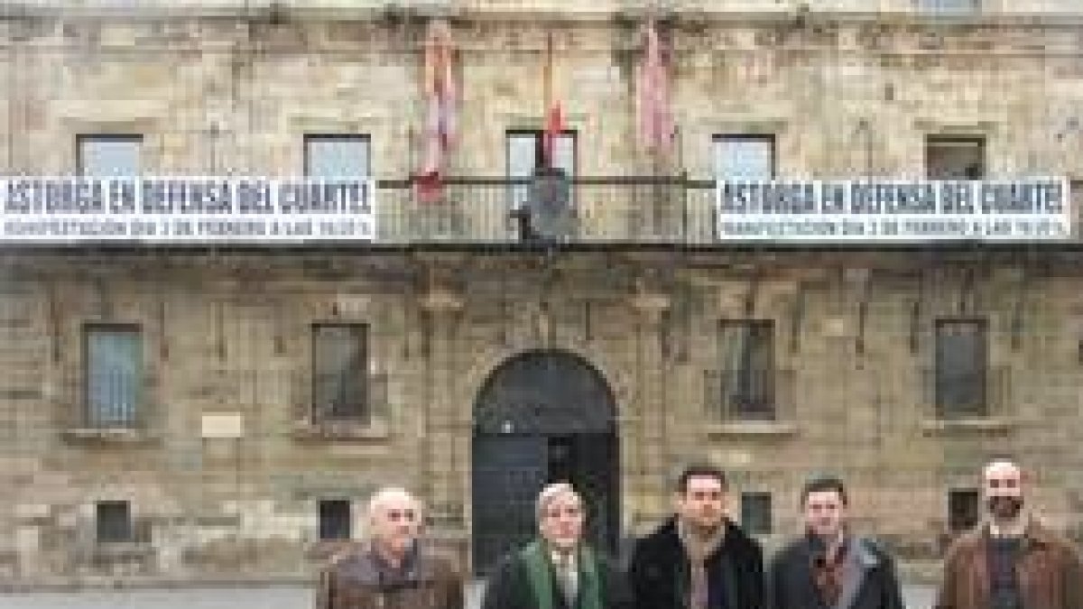 Los miembros de la plataforma posan ante el Ayuntamiento, en el que ya se anuncia la manifestación