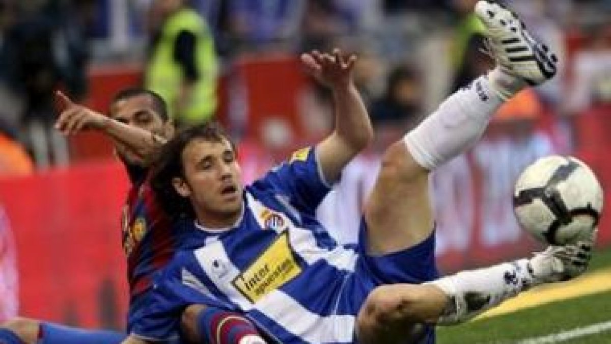 Dani Alves, izquierda, pelea con Verdú en el derbi catalán.