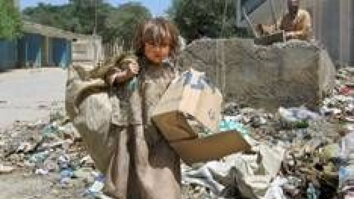 Una niña recoge basura en el centro de Kabul