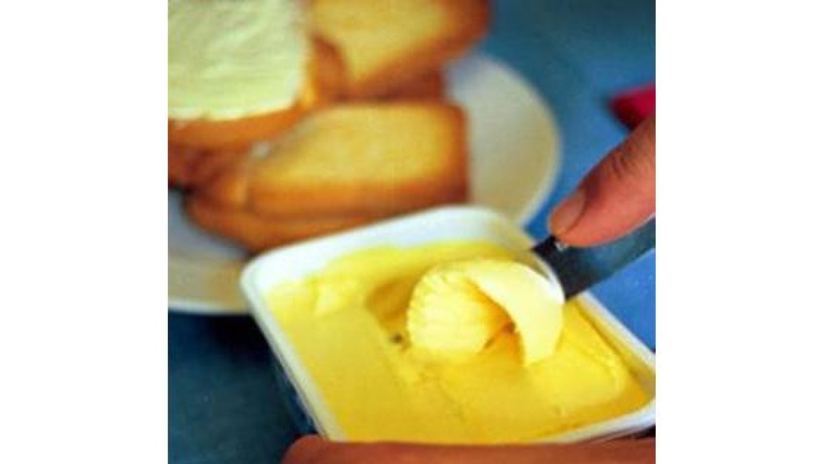 Una persona se prepara una tostada con mantequilla.