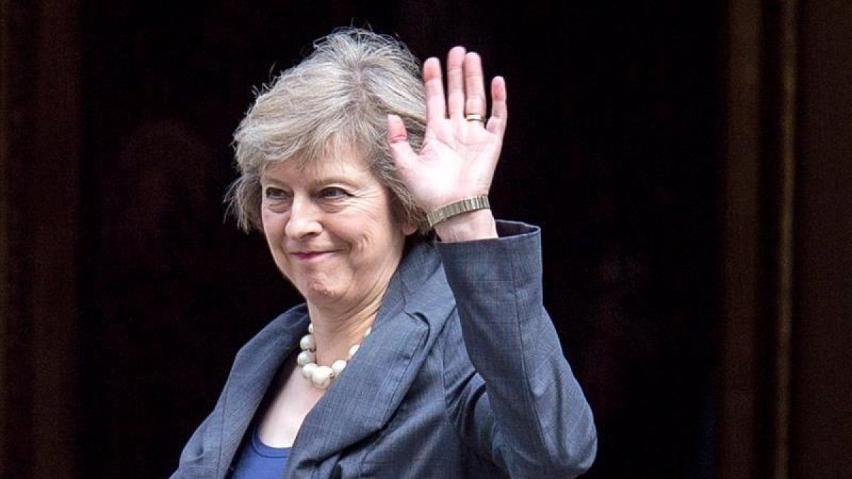 La ministra del Interior británica, Theresa May, saluda a los medios a su llegada a Downing Street para asistir al último consejo de ministros con David Cameron como anfitrión en Westminster, en el centro de Londres.
