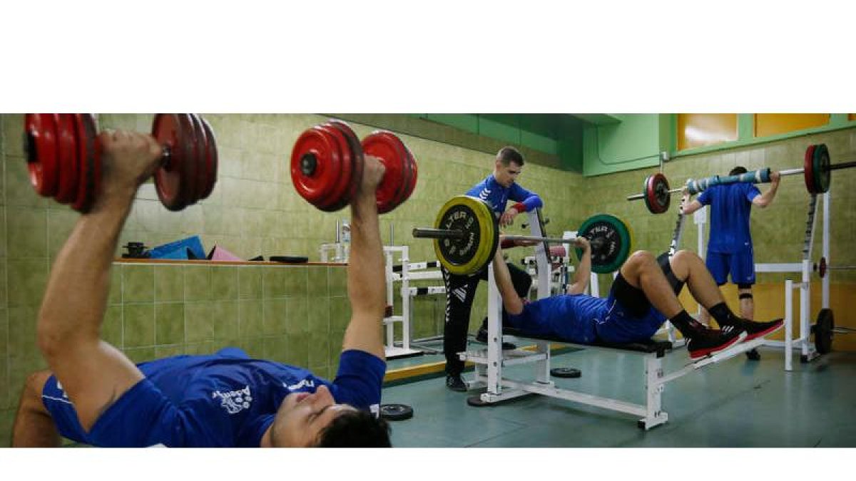 Los jugadores del Abanca Ademar realizan ejercicios de fuerza en el gimnasio del Palacio de Deportes.