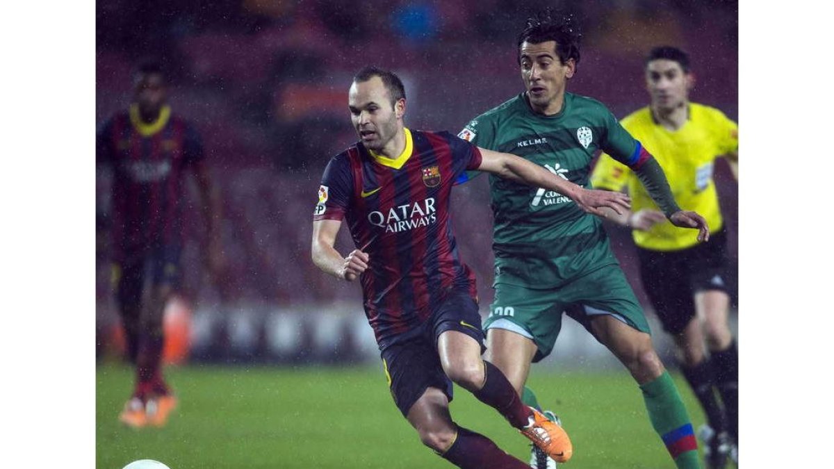 Iniesta, que salió como titular conduce el balón superando la defensa del levantinista Ríos.