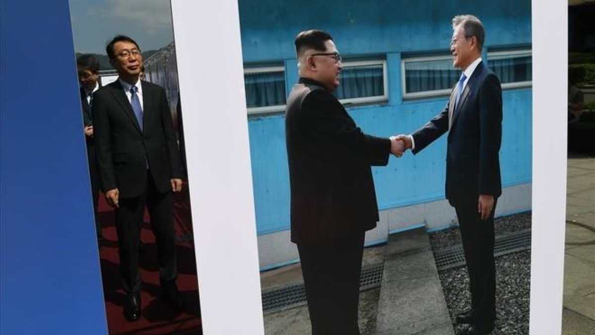 Un alto funcionario surcoreano observa una foto del presidente de Corea del Sur, Moon Jae-in, y del de Corea del Norte, Kim Jong-un, expuesta en Pyongyang.