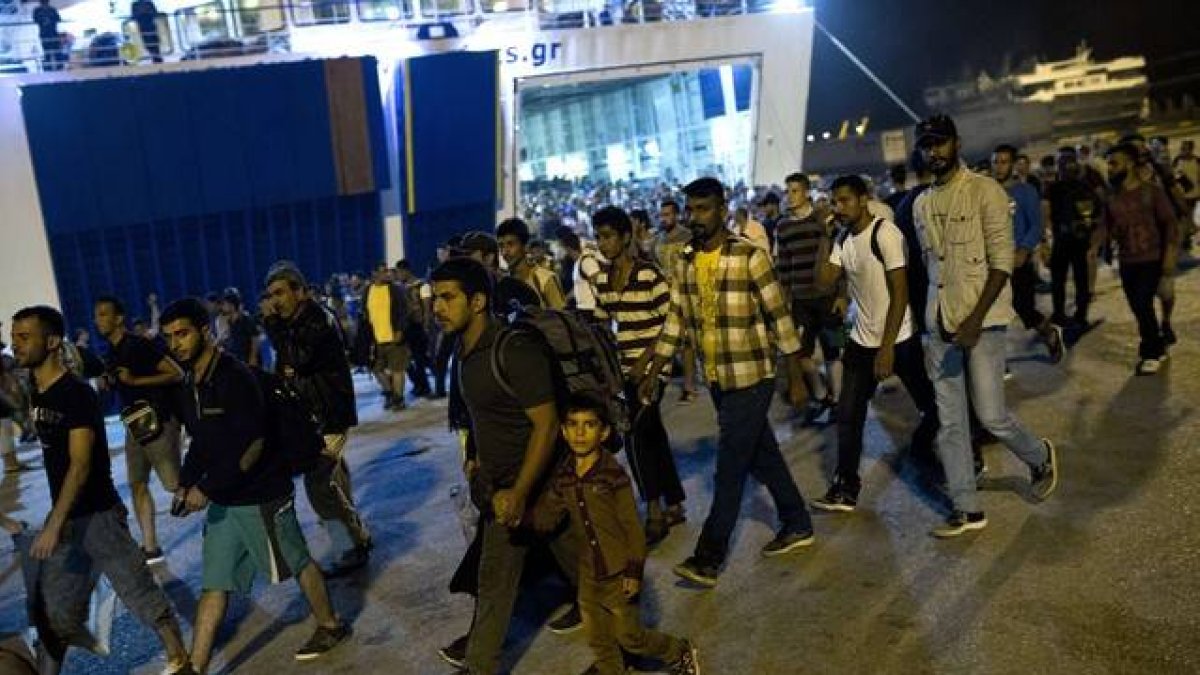 Cientos de inmigrantes desembarcan de un ferry en el puerto de El Pireo, cerca de Atenas, la noche del martes.
