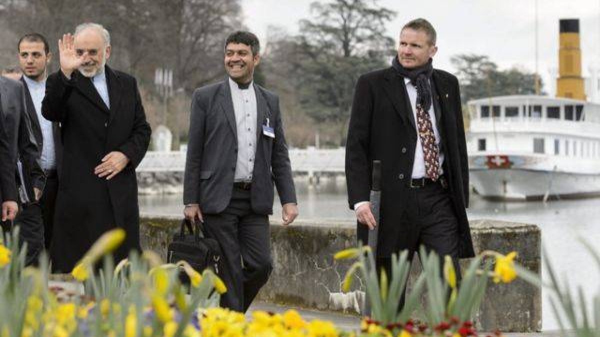 El director de la Organización de Energía Atómica de Irán, Ali-Akbar Salehi (i), saluda a la prensa a su paso por el lago Ginebra antes de asistir a una reunión con los jefes de la diplomacia de EEUU, John Kerry, y de Irán, Mohamad Yavad Zarif (no fotogra