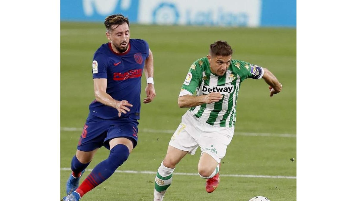 Joaquín Sánchez conduce el balón ante el mexicano del Atlético de Madrid Héctor Herrera. JOSE M. V.