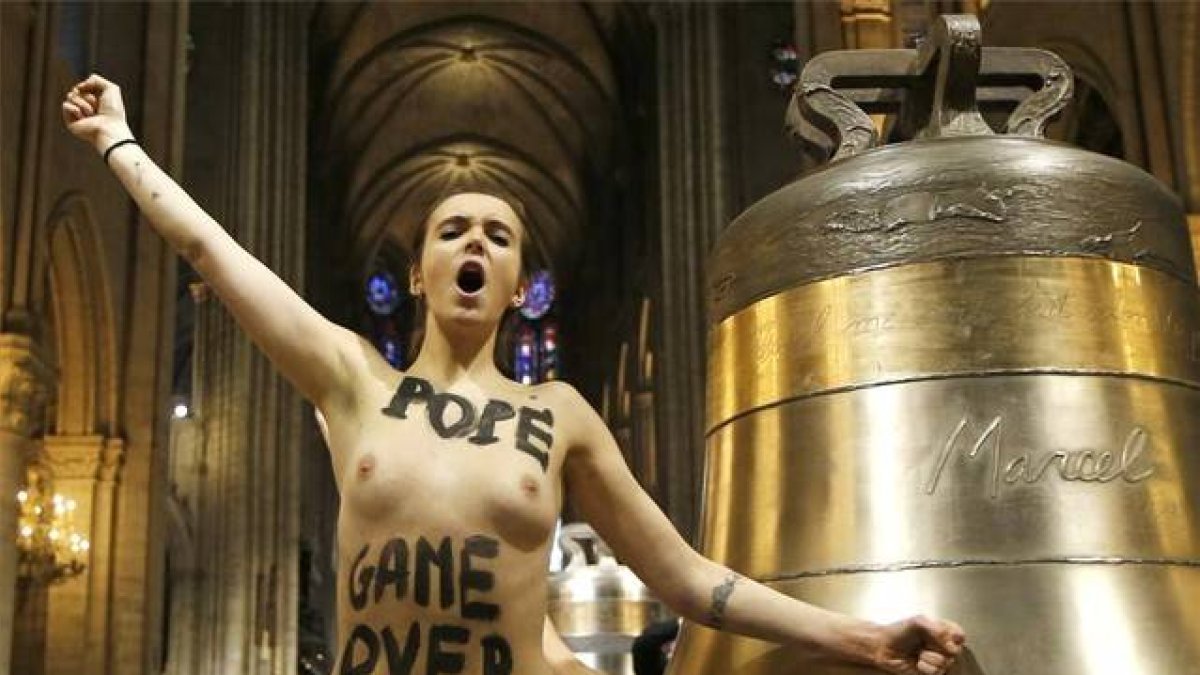 Una de las feministas lanza sus consignas junto a una de las campanas de la catedral de Notre-Dame de París.