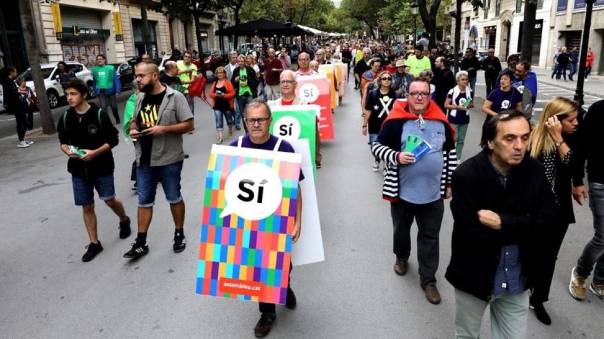 Carteles humanos con propaganda en favor del sí al referéndum en el centro de Barcelona
