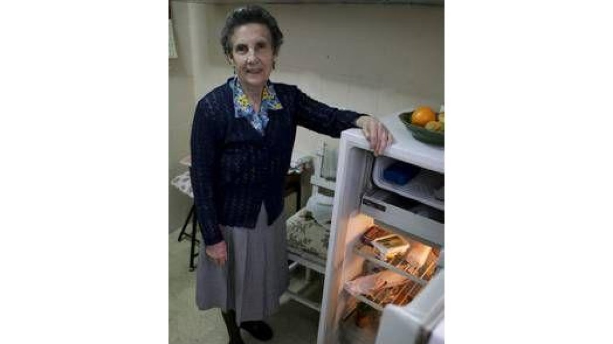 Elisa muestra su nevera, donde conserva los alimentos básicos