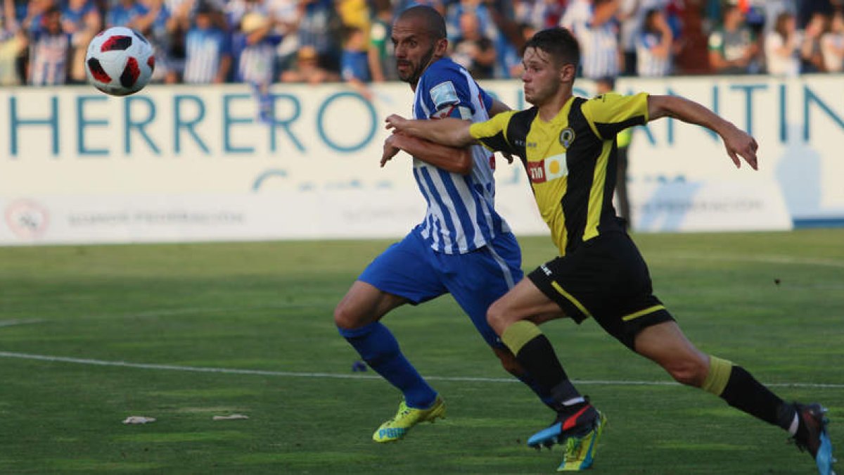 Yuri se lleva el balón en una acción del choque de vuelta de la tercera eliminatoria del play off de ascenso a Segunda División en El Toralín. L. DE LA MATA/ANA F. BARREDO