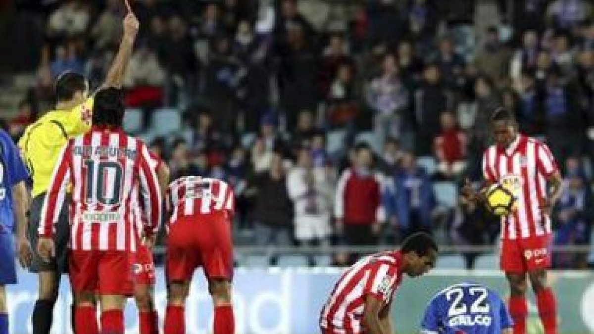 Álvarez Izquierdo muestra la cartulina roja al centrocampista del Atlético, Paulo Assunçao.