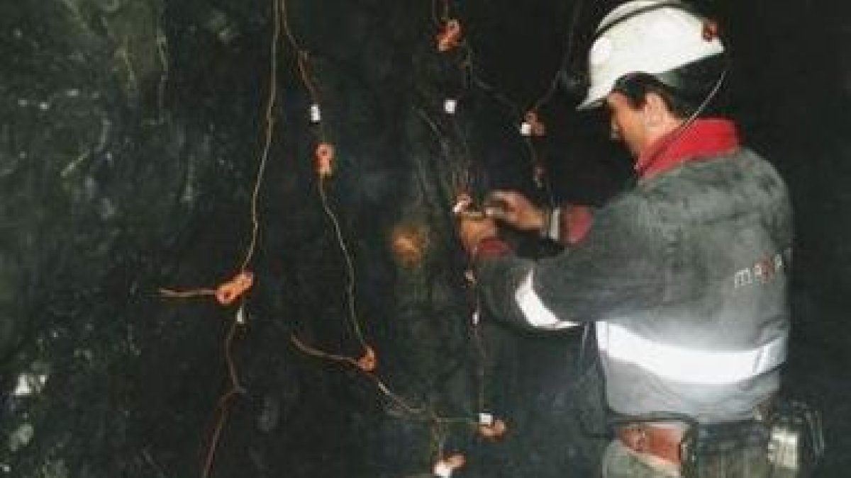 Un trabajador coloca explosivos en el interior de una mina