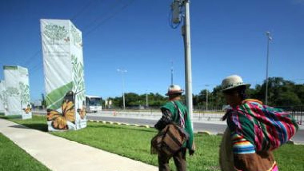Indígenas caminan junto a la sede de la cumbre.