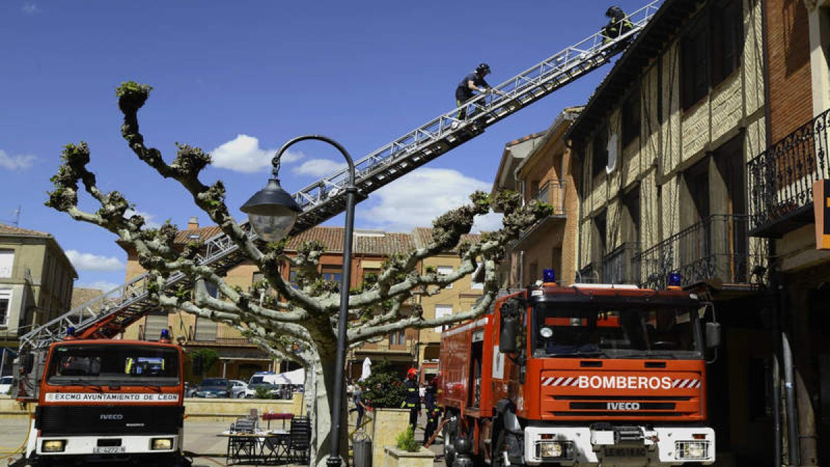 Los bomberos de León, sobre la cubierta del edificio, comprobando la misma tras el incendio. ACACIO