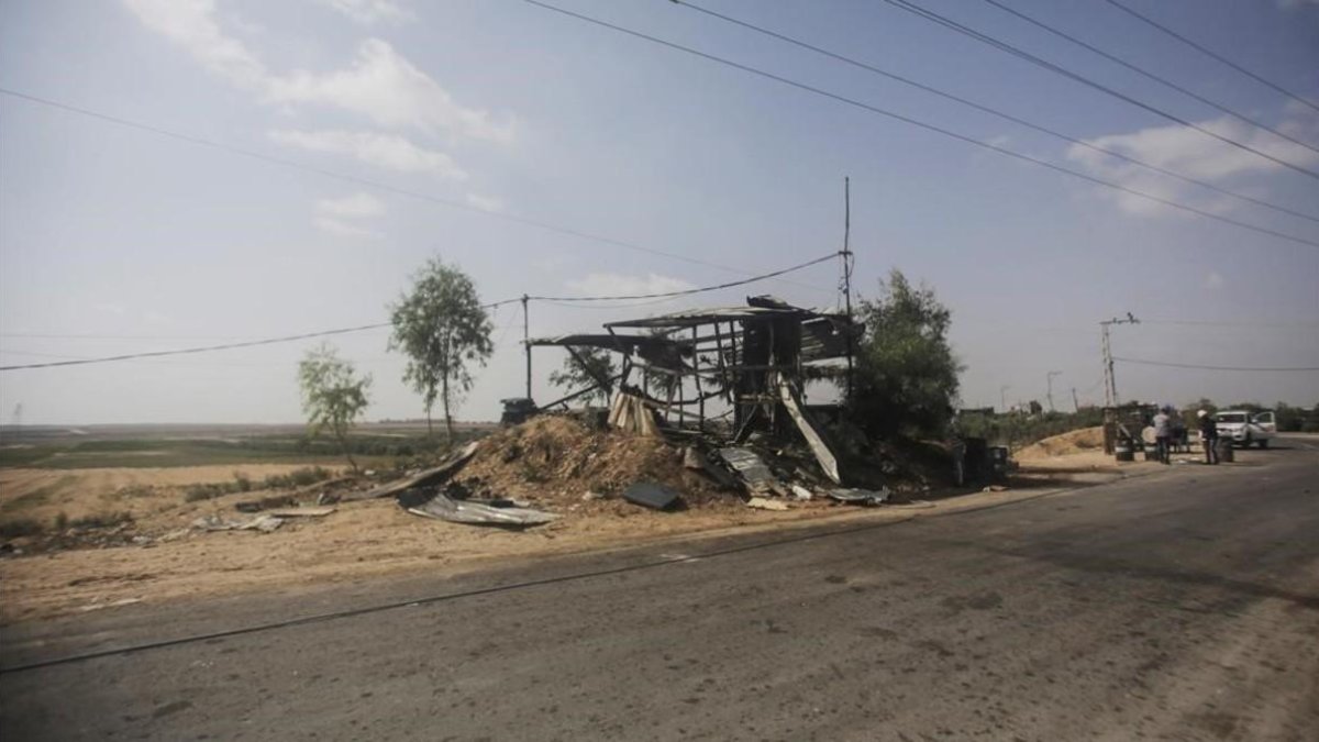Varios palestinos observan un puesto militar destrozado cerca de la frontera con Israel. /