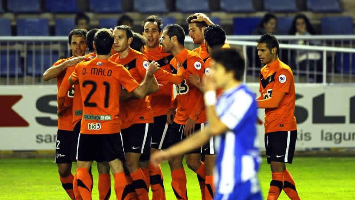 Los jugadores de la Ponferradina, que ayer vistió de naranja, hacen piña para celebrar el tanto de Javi Navarro que le reportó al plantel berciano el triunfo y los tres puntos en Vitoria.