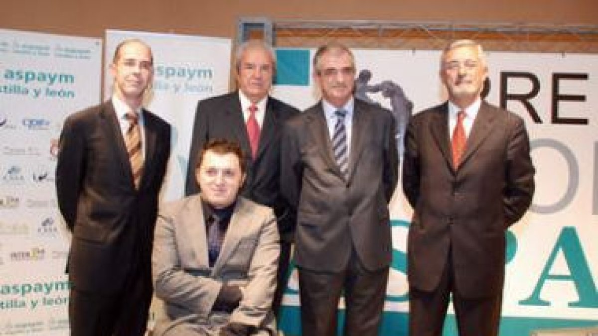 El presidente de Aspaym (sentado) y el consejero Guisasola, con los premiados.