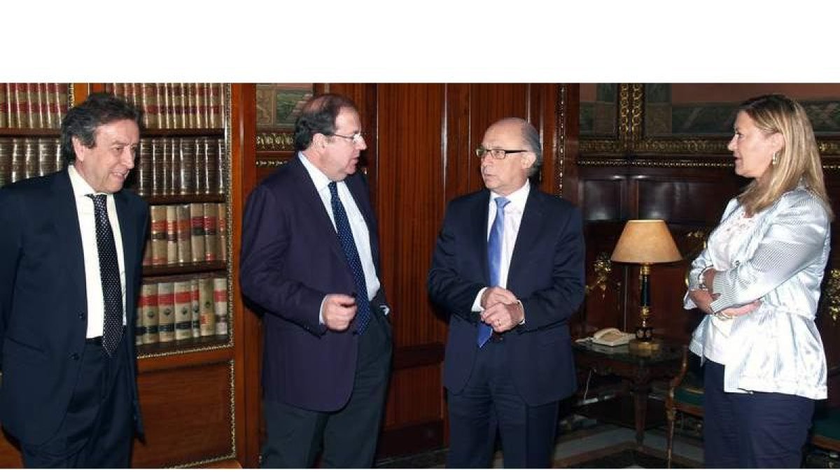 El presidente Herrera conversa con el ministro Montoro, en su despacho, en presencia de los consejeros De Santiago-Juárez y Del Olmo, ayer en Madrid.