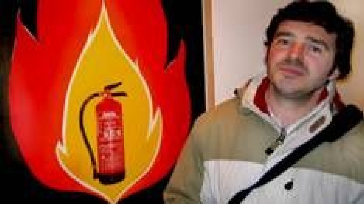 El artista Fermín Santos posa delante de una de las obras expuestas en la Escuela de Arte