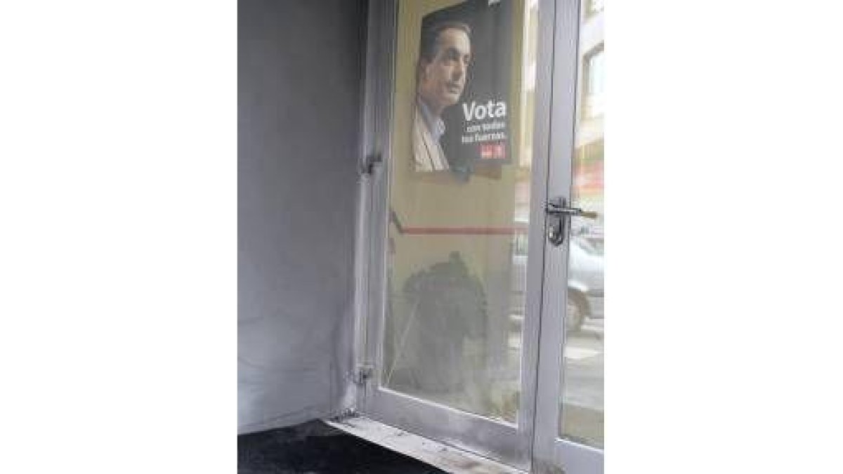 Estado en que quedó la puerta y el felpudo de la sede del PSOE de León