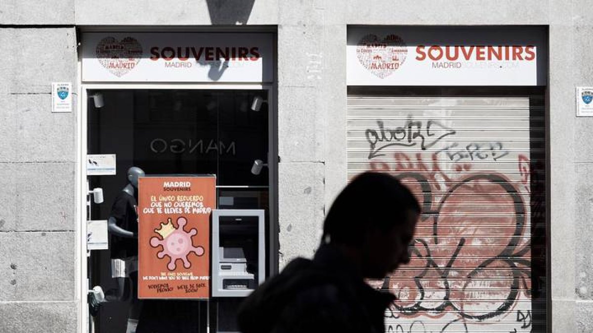 Una persona pasa delante de establecimientos cerrados durante el estado de alarma por la pandemia del coronavirus. A. MÁRQUEZ