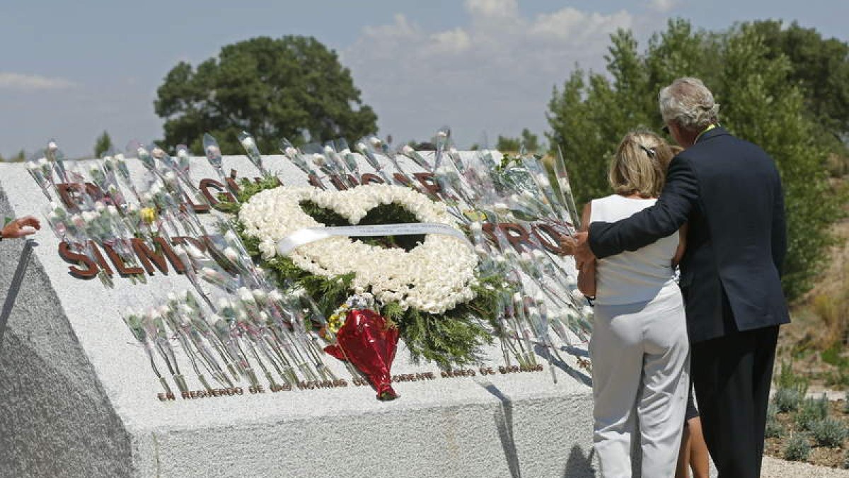 Familiares de las víctimas del accidente, ante un corazón de rosas blancas.