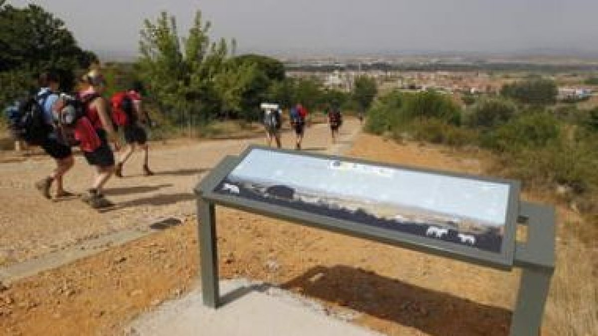 Los peregrinos junto al cartel, situado en un lugar con una impresionante panorámica.