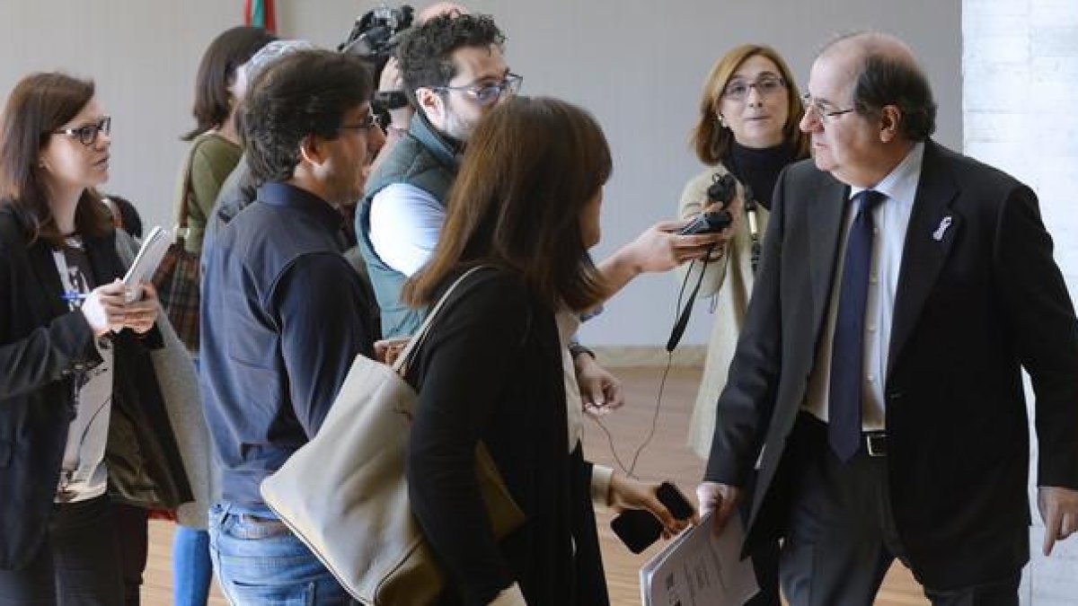 El presidente de la Junta de Castilla y León, Juan Vicente Herrera (d), es perseguido por un grupo de periodistas por los pasillos de las Cortes de Castilla y León.