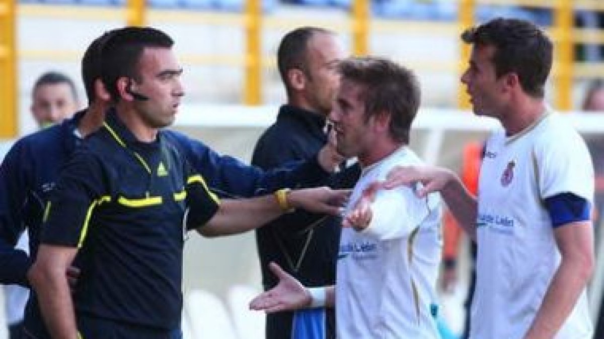 Quique y Santi Santos, piden explicaciones al árbitro Corral García por no señalar un claro penalti.