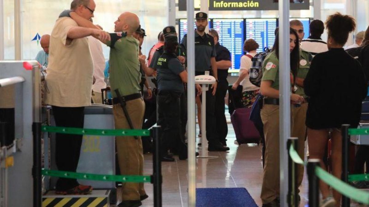 Pasajeros en los controles de seguridad de El Prat, el primer día de huelga total.