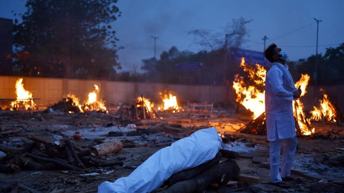 Un hombre eleva sus oraciones antes de encender la pira de un cadáver. IDREES MOHAMMED