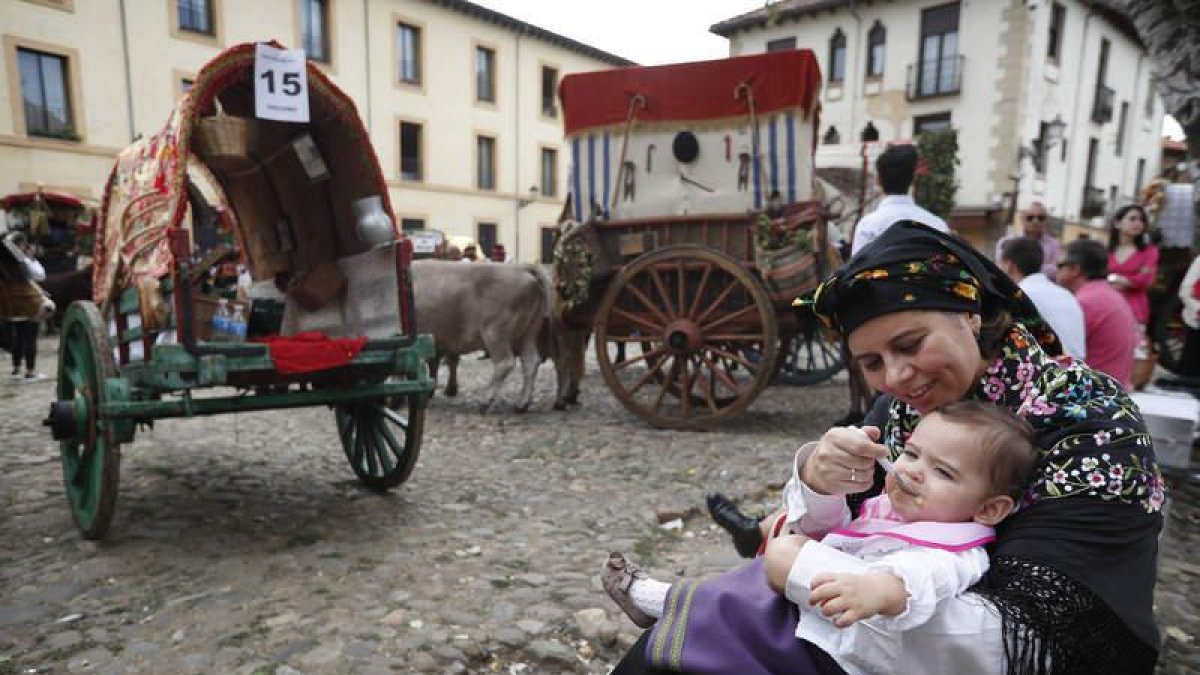 Uno de los participantes más jóvenes del tradicional desfile de los carros engalanados repone fuerzas al final del recorrido, en la Plaza del Grano.
