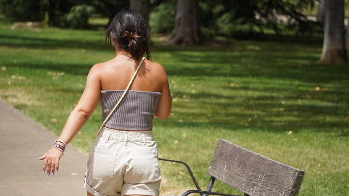 Una chica pasea por un parque en plena ola de calor. J. NOTARIO