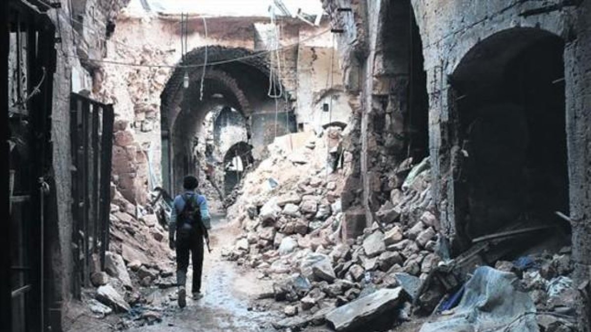 Un miliciano camina por entre las ruinas que han dejado los bombardeos en el zoco antiguo de Alepo, una ciudad habitada desde hace 7.000 años.