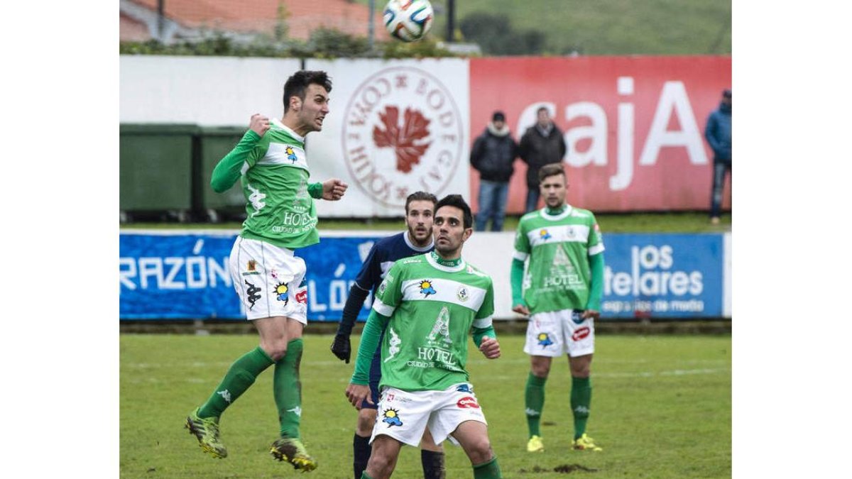 Rubén desvía de cabeza bajo la mirada de Porfirio y Cristian un centro del equipo asturiano