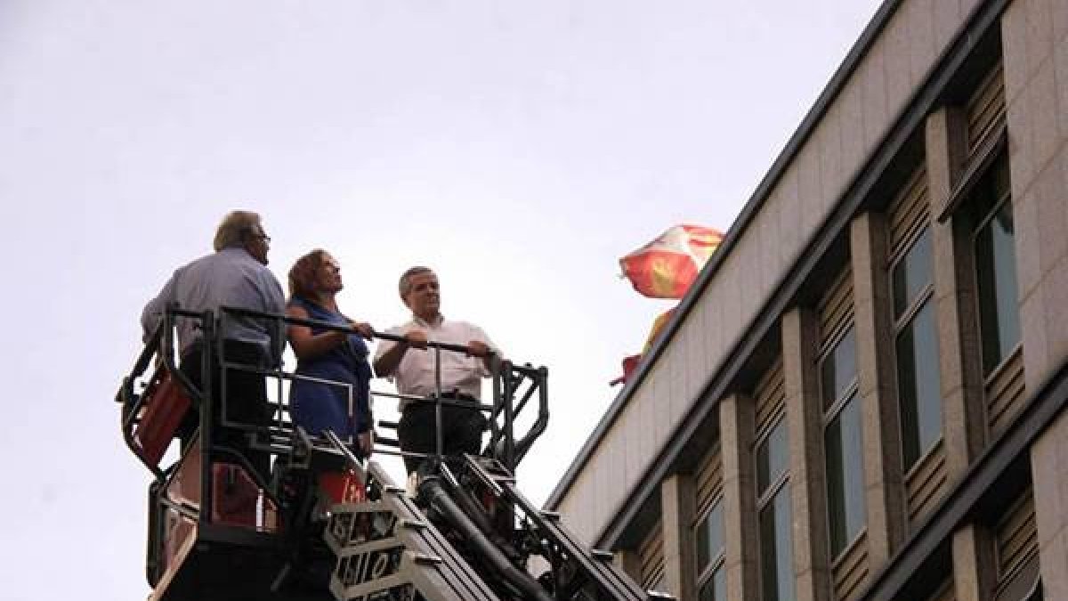 El alcalde de la ciudad, Emilio Gutiérrez, junto a la concejala de Comercio, observa el desarrollo de los efectivos desplegados para acabar con el fuego en el edificio del Ayuntamiento de León.