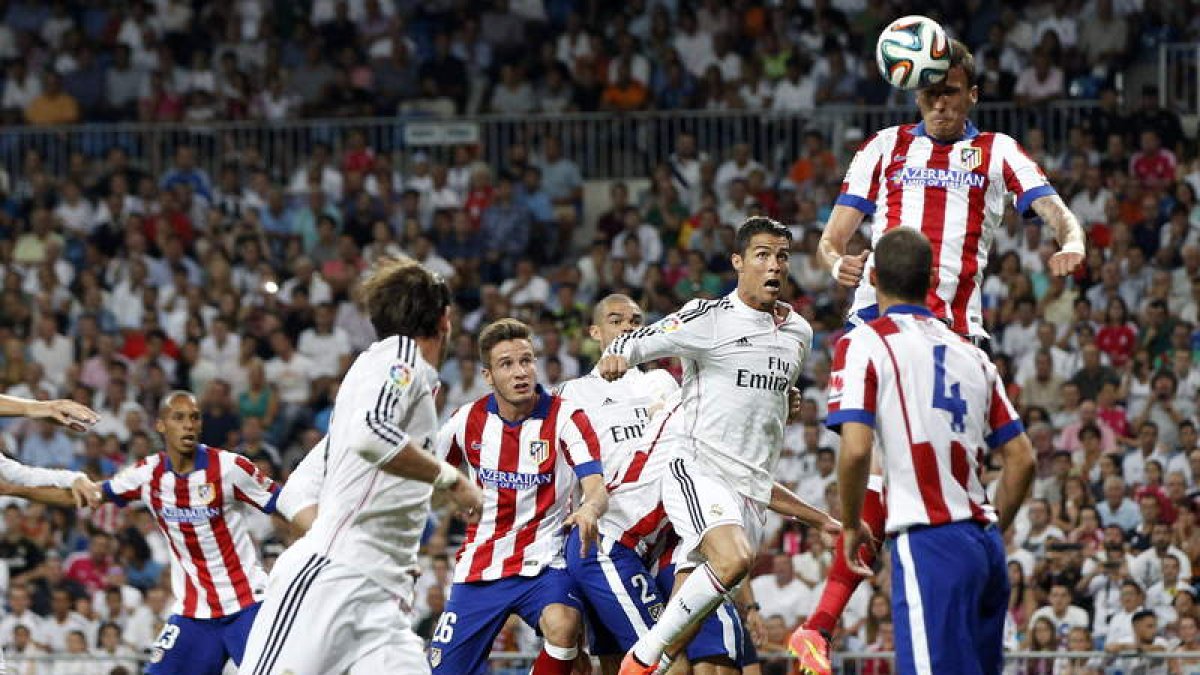 Siqueira despeja de cabeza una jugada dentro del área del Atlético con Cristiano Ronaldo, que acabó lesionado, al acecho.