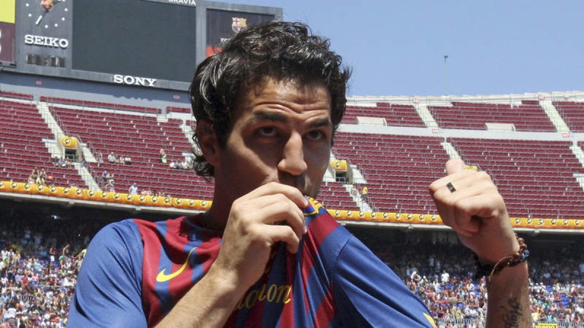 Cesc Fábregas besa el escudo del que es su nuevo equipo después de firmar ayer su contrato.