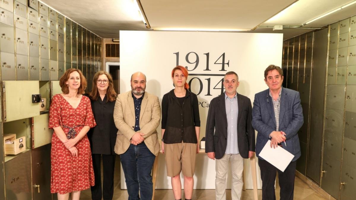 La artista Marta PCampos (C) junto a los asistentes a la inauguración del proyecto expositivo que recopila las casi 2.800 palabras que en 1914 tenían su propia entrada en el diccionario, pero que, un siglo después, habían desaparecido