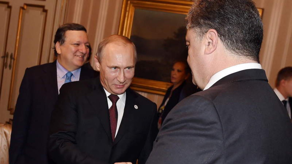 Putin estrecha la mano de Poroshenko.
