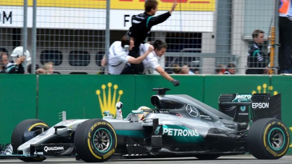 Hamilton celebra el triunfo en Alemania al paso frente a sus mecánicos.